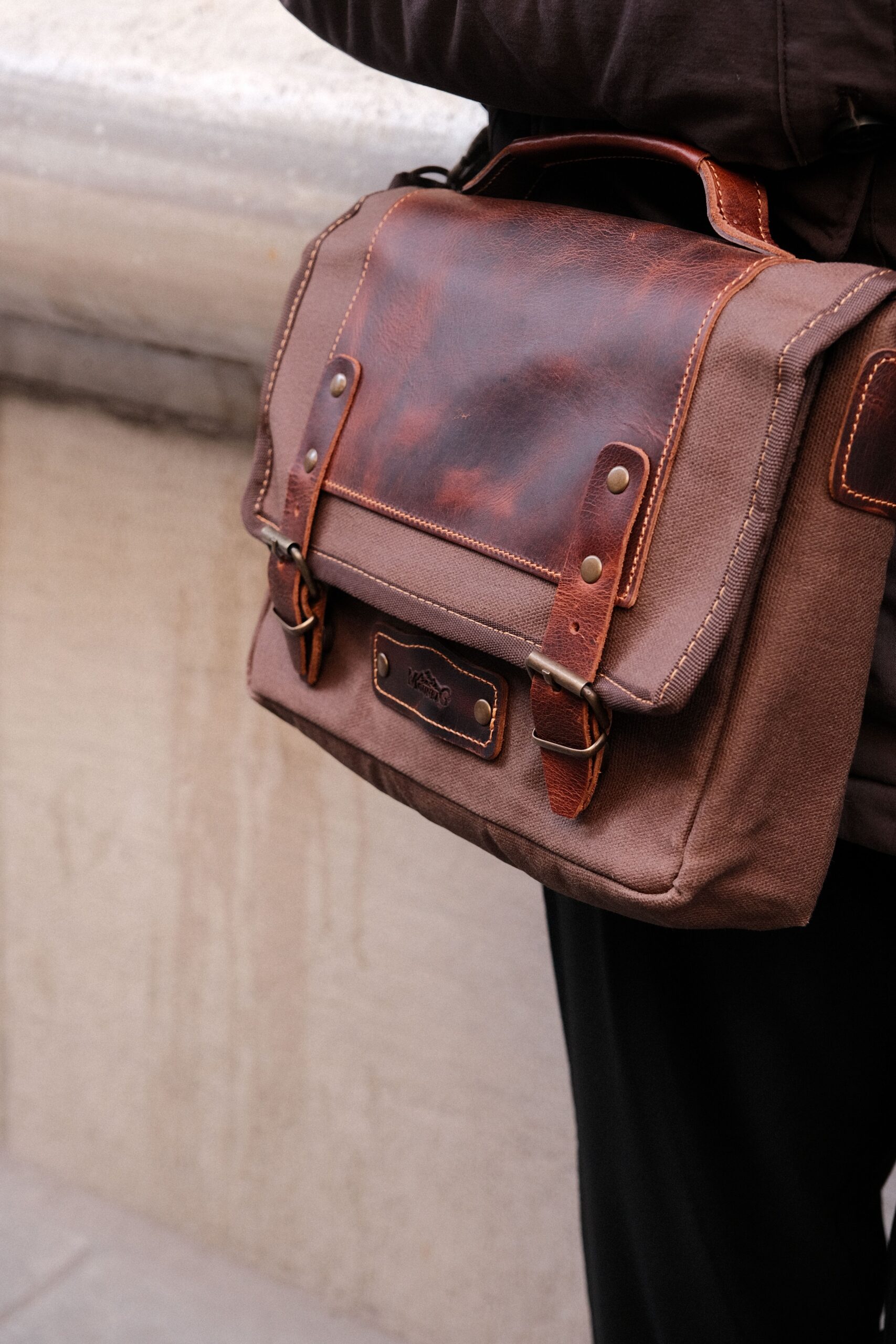 Brown canvas and leather satchel carried over the shoulder, heritage styling
