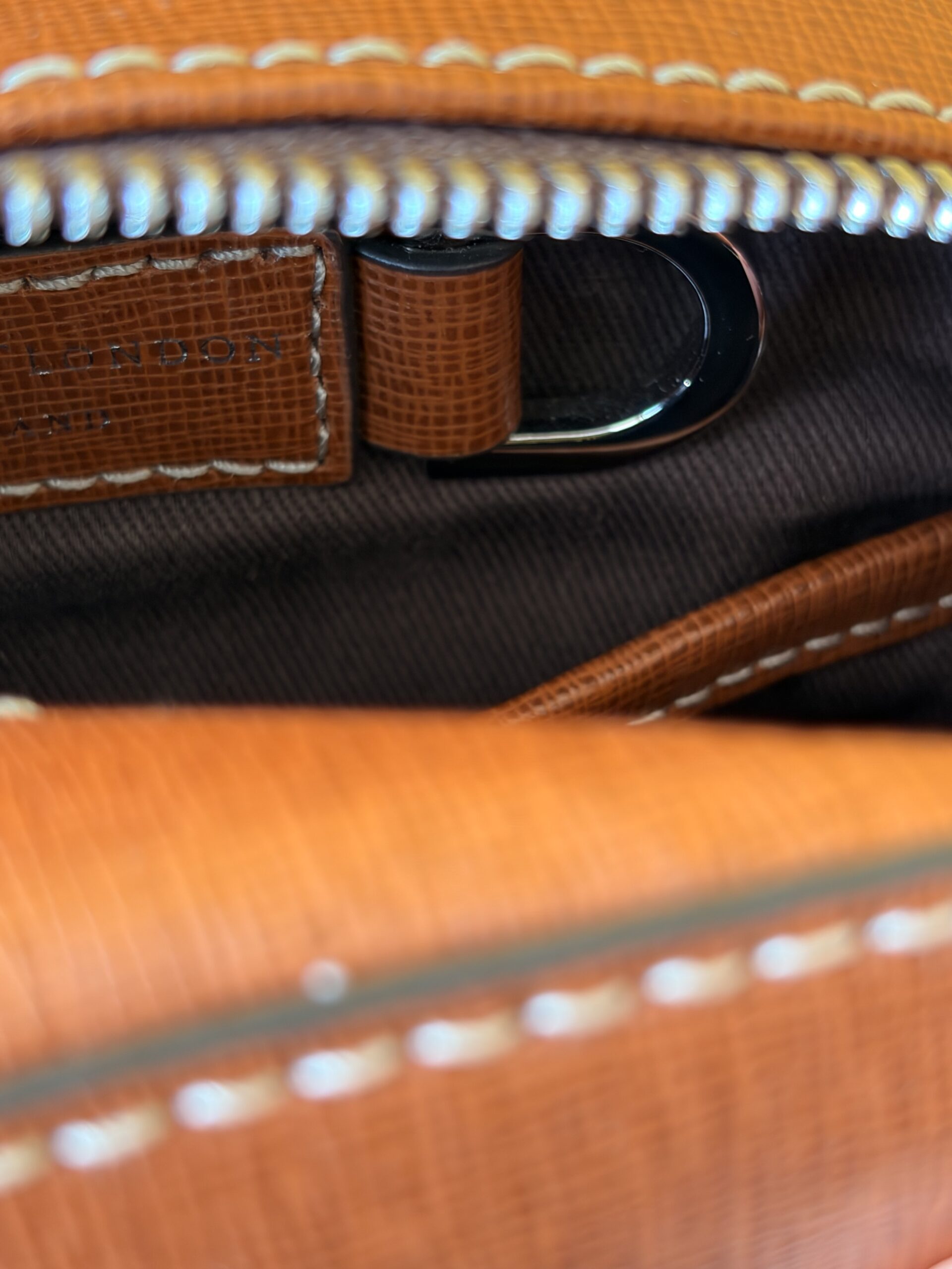 Looking into the main compartment of the Reporter North South, showing the dark cotton lining and an interior D-ring