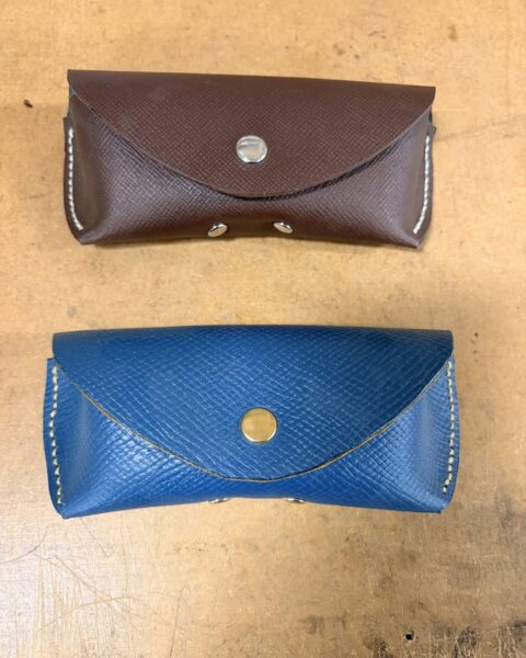 Two sample glasses cases in saffiano leather, brown and cobalt, contrast stitching and snap closure, at Leather4Craft in Newhaven
